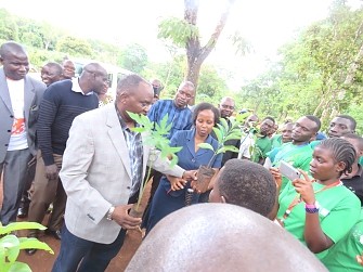 Kigoma Regional Commissioner and REDESO Project Coordinator distributing tree seedlings to beneficiaries in Nduta camp